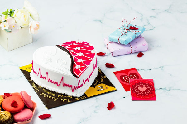 A cake with two hearts adjoined in red and white theme with golden dots. A  cake perfect for anniversary – Creme Castle